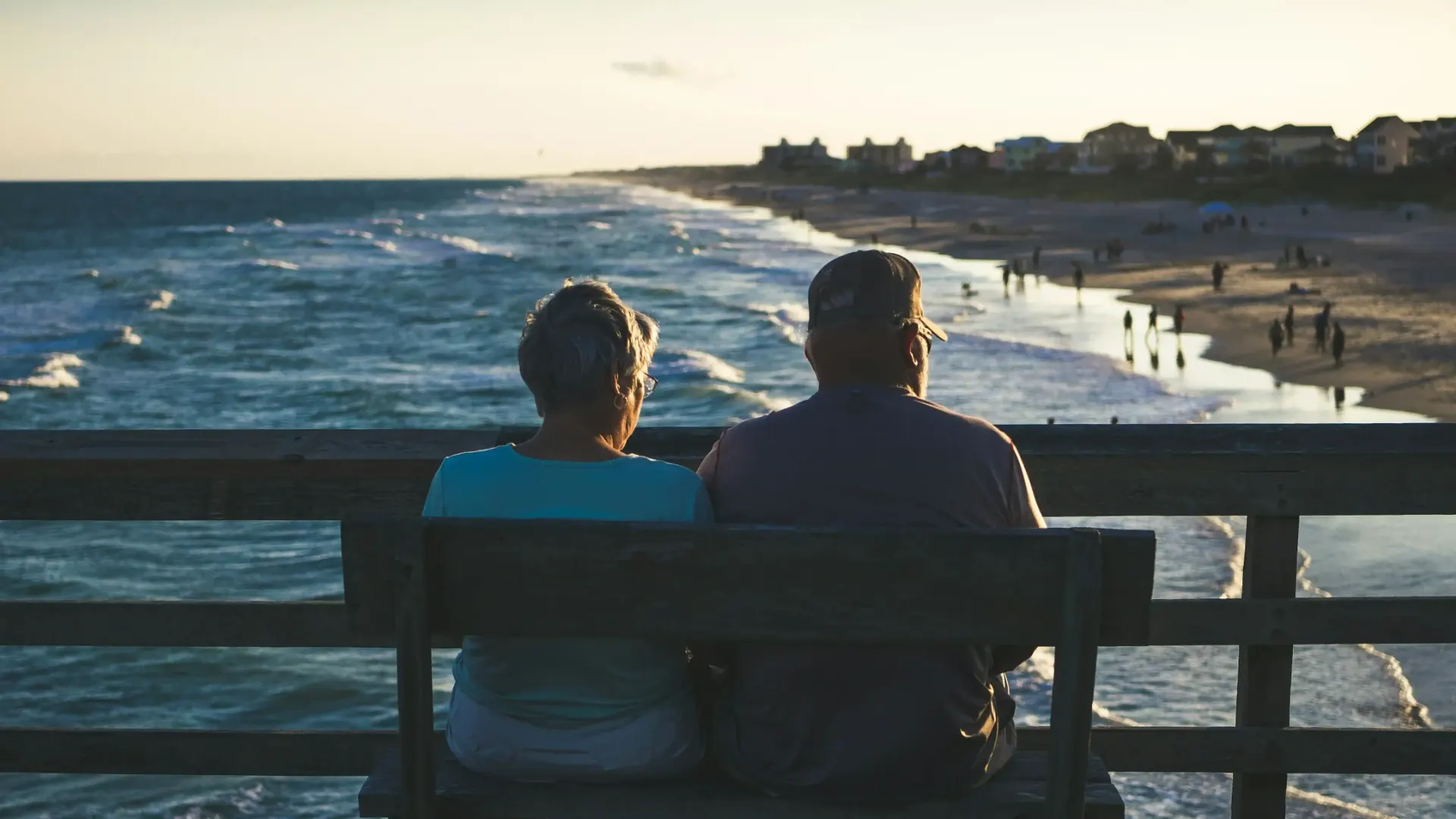Pareja de adultos mayores frente al mar al atardecer, que ilustra la asesoría de pensión IMSS de Rodríguez Bravo y Asociados para planear el retiro sin pérdidas.