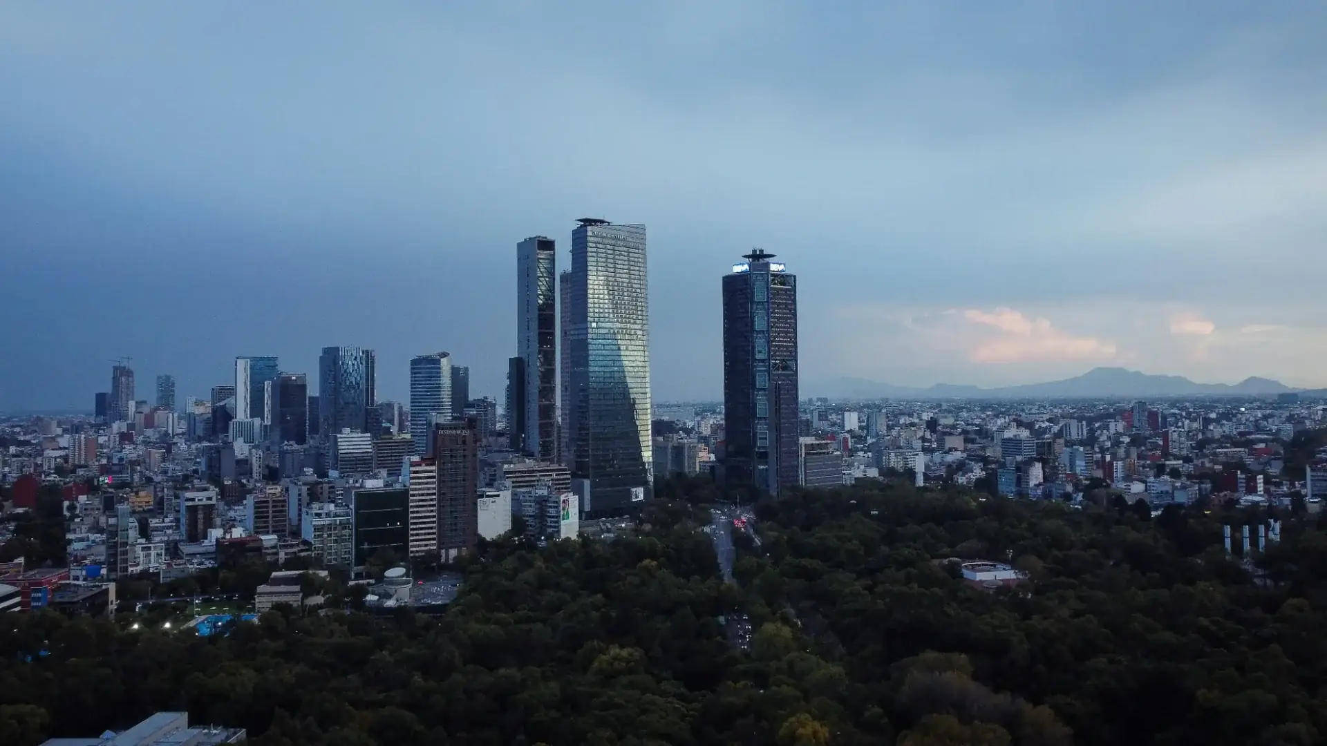 Panorama corporativo de la Ciudad de México al atardecer: edificios de Reforma y Chapultepec que ilustran los servicios preventivos IMSS de Rodríguez Bravo y Asociados para proteger el patrimonio empresarial ante requerimientos patronales.